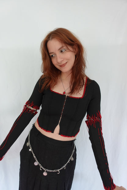 Person wearing a black outfit with red accents on a white background